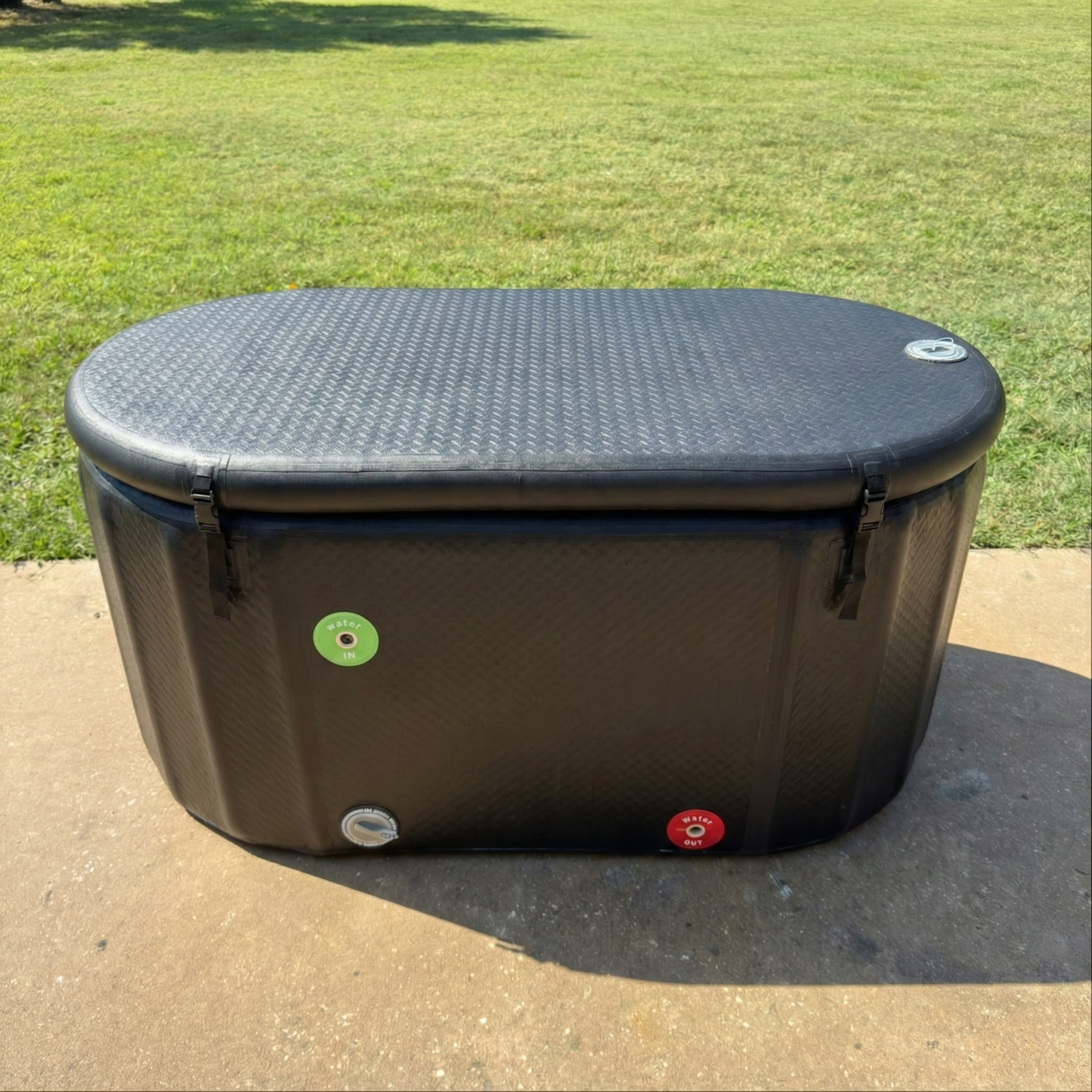 XL Black ice tub for cold plunge on a concrete surface with grass in the background